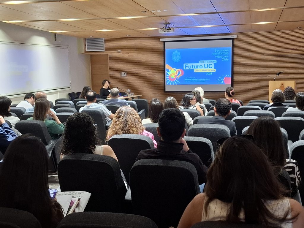 Fotografía de un auditorio con una presentación de fondo