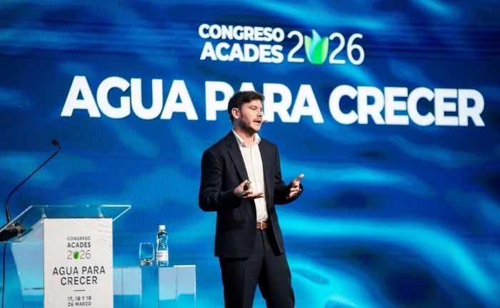 Fotografía del profesor Iván Sola presentando en Congreso ACADES 2026 se ve de fondo
