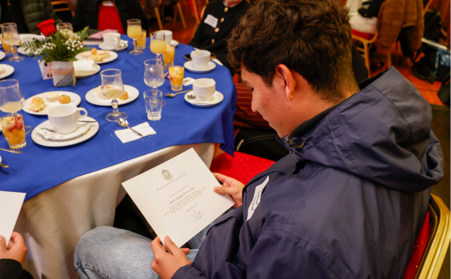 Fotografía de una persona viendo y leyendo un diploma en sus manos